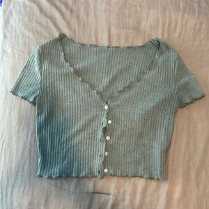 Teal cropped top with white buttons and lettuce trim hems